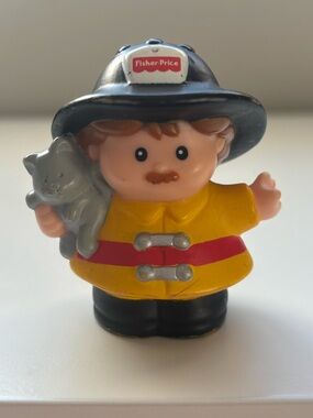 Little people fireman holding a kitten